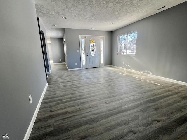 entrance foyer featuring a textured ceiling and dark hardwood / wood-style floors