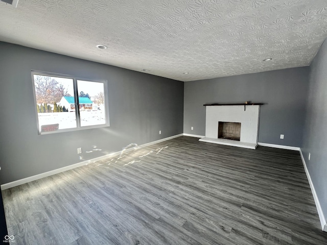 unfurnished living room featuring a textured ceiling and dark hardwood / wood-style floors