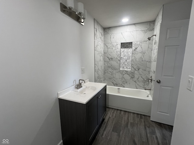 bathroom featuring vanity, hardwood / wood-style flooring, and tiled shower / bath