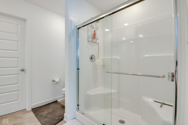 bathroom with tile patterned flooring, toilet, and walk in shower