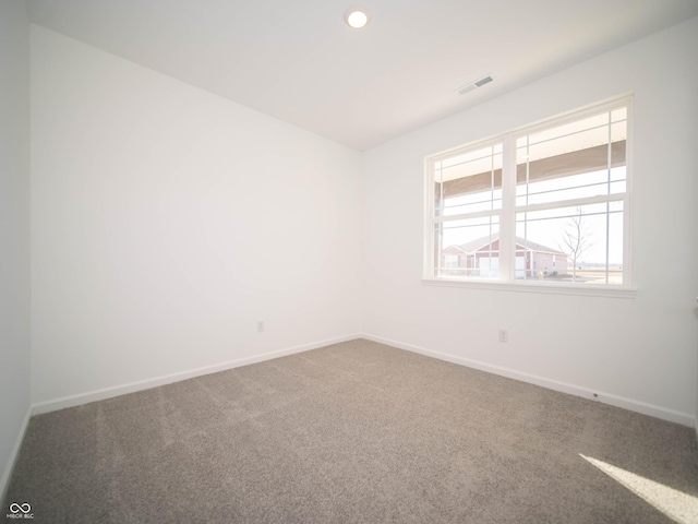 carpeted empty room with recessed lighting, visible vents, and baseboards