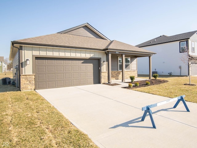 view of front facade featuring stone siding, a garage, board and batten siding, and a front yard