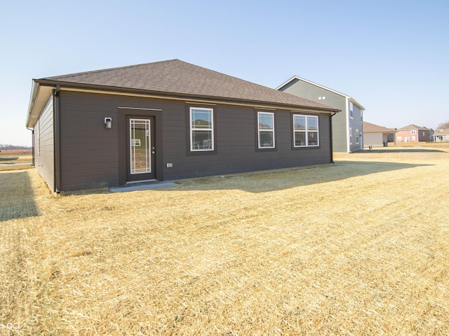 rear view of house with a shingled roof