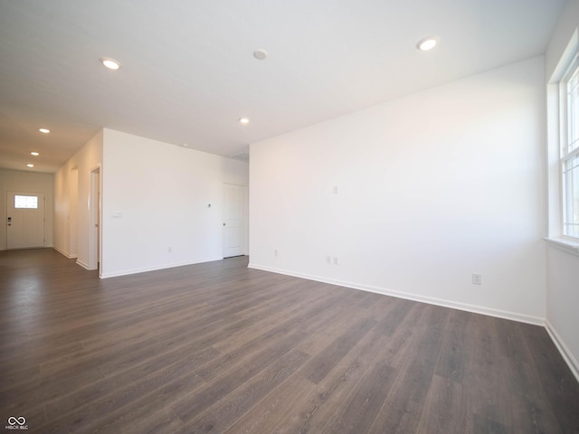 empty room with recessed lighting, dark wood-type flooring, and baseboards