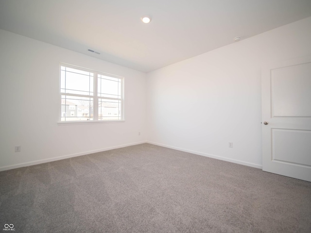 empty room with baseboards, visible vents, and carpet floors