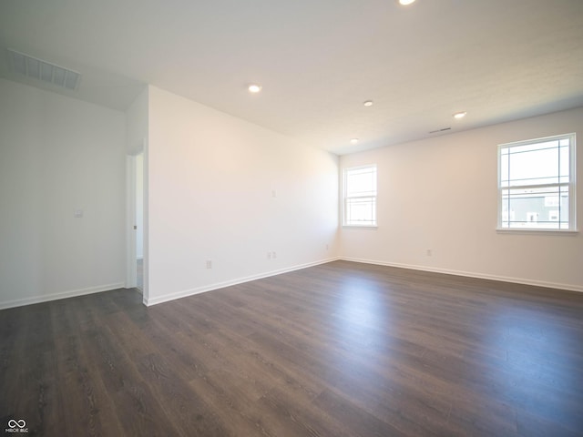 empty room featuring recessed lighting, visible vents, baseboards, and dark wood finished floors