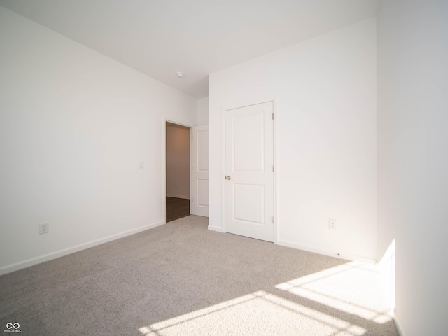 carpeted spare room with baseboards