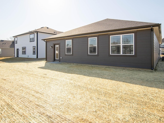 rear view of house featuring roof with shingles