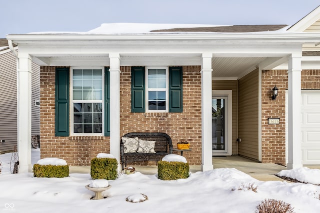 snow covered property entrance featuring covered porch