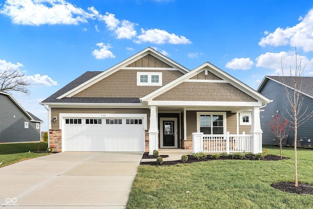 craftsman-style home featuring covered porch, a front lawn, and a garage