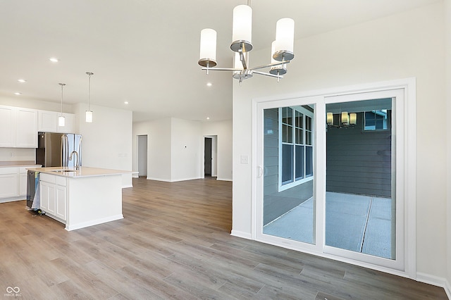 kitchen with white cabinetry, a kitchen island with sink, sink, pendant lighting, and stainless steel appliances