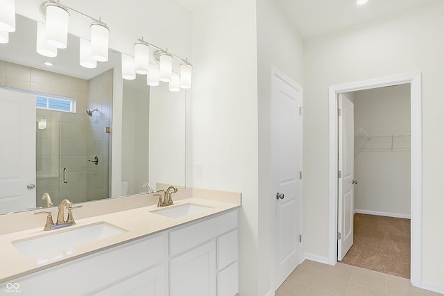 bathroom featuring tile patterned floors, an enclosed shower, and vanity