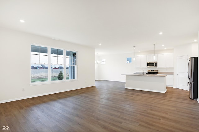 unfurnished living room with dark wood-type flooring and sink