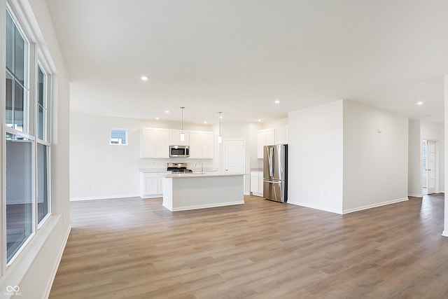 unfurnished living room with sink and light wood-type flooring