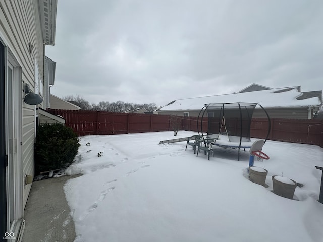 yard covered in snow featuring a trampoline