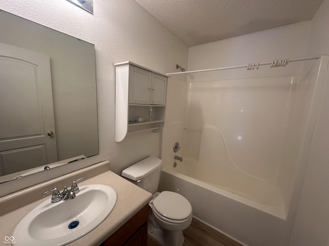 full bathroom with toilet, a textured ceiling, hardwood / wood-style floors, shower / bath combination, and vanity