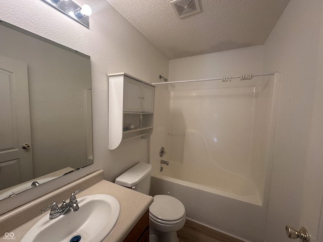 full bathroom featuring wood-type flooring, toilet, vanity, a textured ceiling, and shower / bathing tub combination