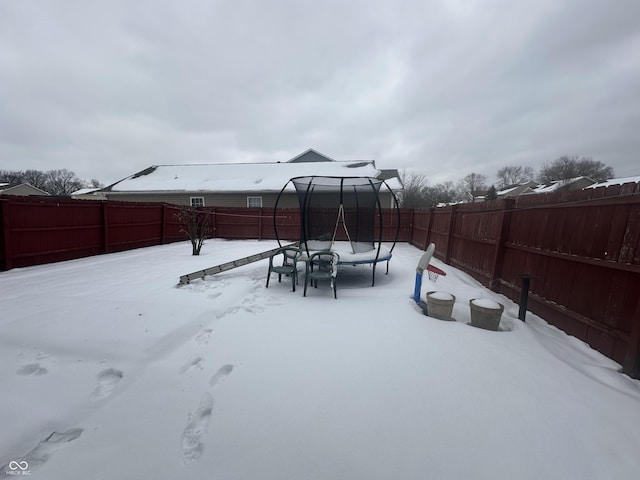 snowy yard with a trampoline