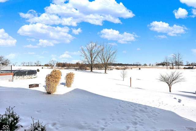 yard layered in snow with a pool