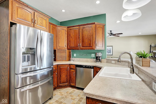 kitchen with kitchen peninsula, appliances with stainless steel finishes, ceiling fan, and sink