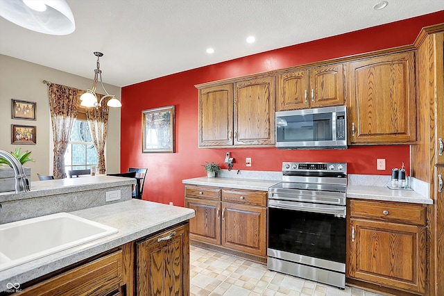 kitchen featuring stainless steel appliances, sink, and hanging light fixtures