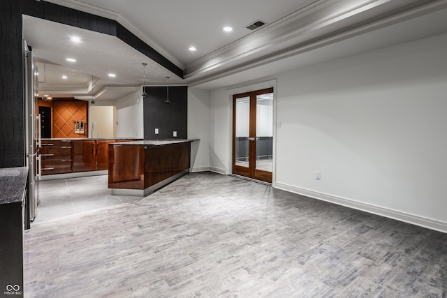 bar featuring crown molding, a tray ceiling, french doors, pendant lighting, and light hardwood / wood-style flooring