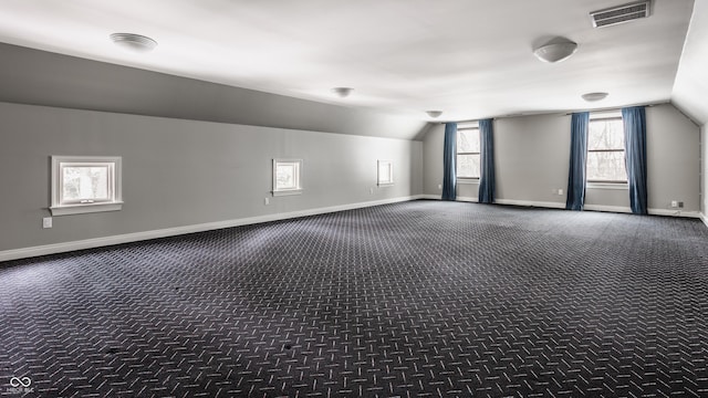 additional living space with lofted ceiling and dark carpet