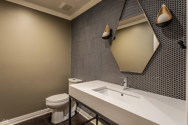 bathroom featuring sink, toilet, and crown molding