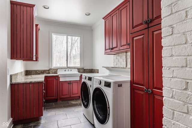 clothes washing area with sink, washer and dryer, ornamental molding, and cabinets