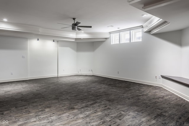 basement featuring ceiling fan, dark wood-type flooring, and crown molding