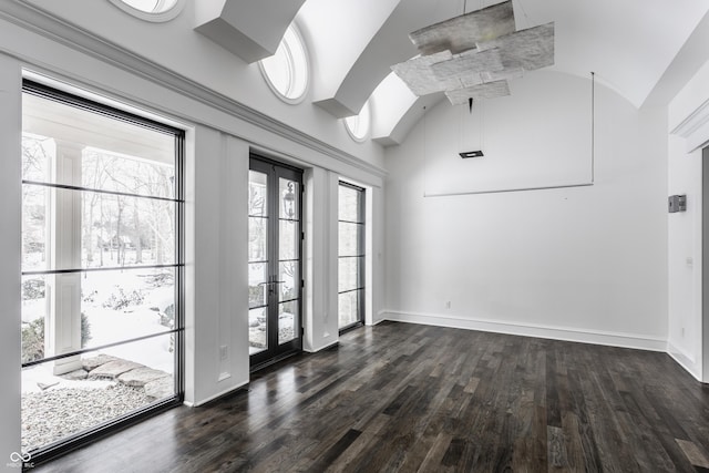 empty room with lofted ceiling, french doors, and dark wood-type flooring