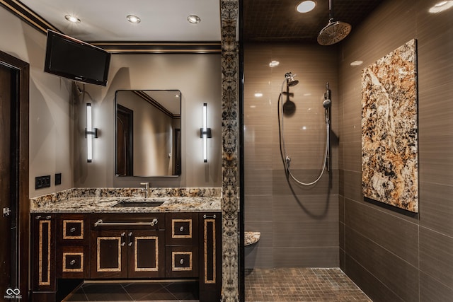 bathroom with tiled shower, vanity, and tile patterned flooring