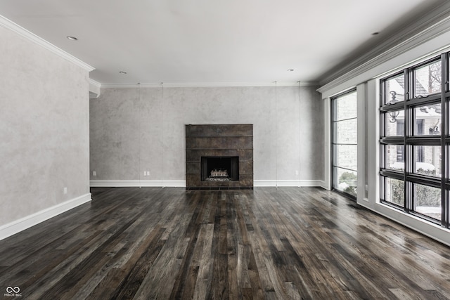 unfurnished living room featuring dark wood-type flooring, ornamental molding, and a fireplace