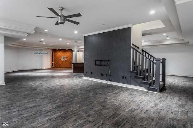 unfurnished living room featuring ceiling fan, dark hardwood / wood-style flooring, crown molding, and a tray ceiling