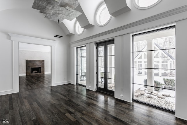 interior space with french doors, a fireplace, a wealth of natural light, and dark hardwood / wood-style flooring