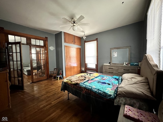 bedroom featuring multiple windows, dark hardwood / wood-style flooring, french doors, and ceiling fan