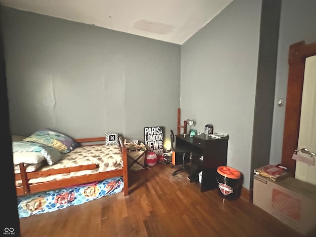 bedroom with wood-type flooring and vaulted ceiling