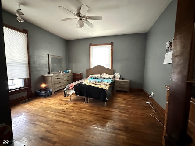 bedroom with multiple windows, wood-type flooring, and ceiling fan