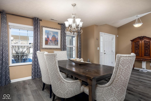 dining room with lofted ceiling, an inviting chandelier, plenty of natural light, and dark hardwood / wood-style floors