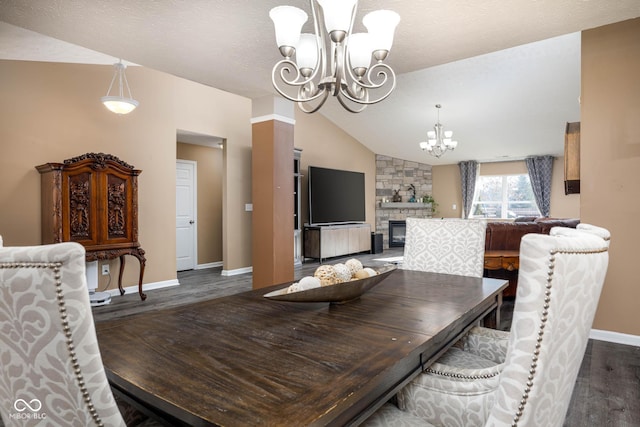 dining room featuring a textured ceiling, a fireplace, vaulted ceiling, and dark hardwood / wood-style floors