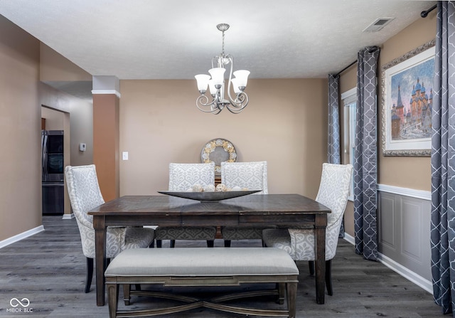 dining room with dark hardwood / wood-style flooring and a chandelier