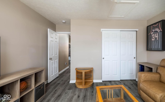 interior space with a textured ceiling and dark hardwood / wood-style flooring