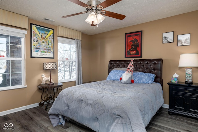 bedroom featuring a textured ceiling, ceiling fan, and dark hardwood / wood-style flooring