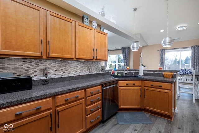 kitchen with hardwood / wood-style floors, pendant lighting, sink, black dishwasher, and backsplash