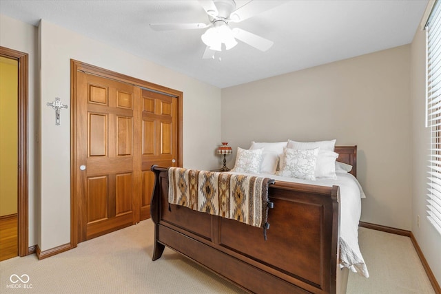 bedroom with ceiling fan, light colored carpet, and a closet