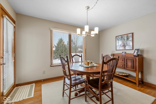 dining space with wood-type flooring and a chandelier