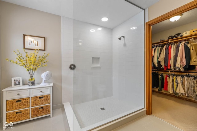 bathroom with tile patterned flooring and a tile shower