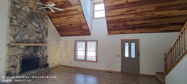 unfurnished living room with a fireplace, high vaulted ceiling, carpet, ceiling fan, and wooden ceiling