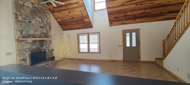 entryway featuring ceiling fan, a stone fireplace, wooden ceiling, and high vaulted ceiling