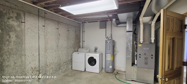 basement with electric water heater and washer and clothes dryer